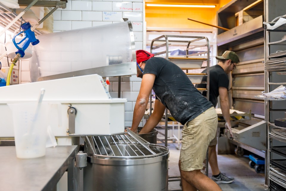 Liquidation matériel boulangerie – une équipe de boulangers en plein travail autour d’un pétrin industriel dans un fournil